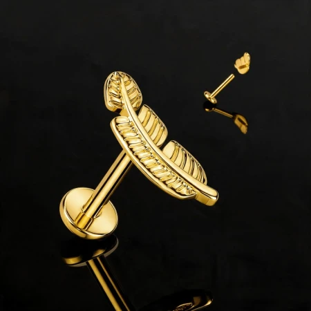 Labret do piercingu z dekoracyjnym topem w kształcie piórka o długości 11,2 mm. Motyw inspirowany naturą nadaje biżuterii lekkości i wyrazistego charakteru, a złote wykończenie PVD podkreśla detale ozdoby i nadaje jej elegancki wygląd.