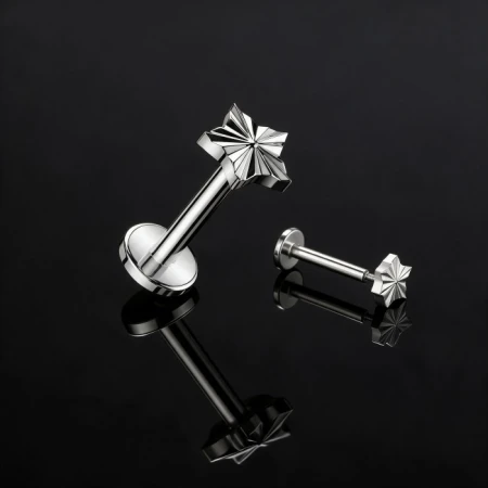 Labret do piercingu z ozdobnym topem w kształcie gwiazdki o średnicy 4,7 mm. Model Diamond Cut Star wyróżnia się precyzyjnie opracowanymi krawędziami, które nadają gwiazdce geometryczny wygląd i efektownie odbijają światło.